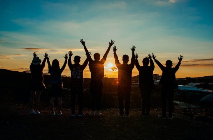 A group of people celebrating with a sunset in the background
