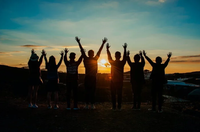 A group of people celebrating with a sunset in the background in Cambridgeshire