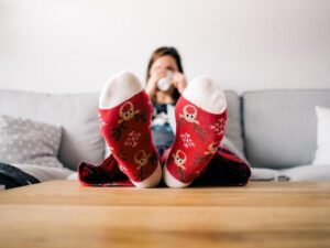 A lady drinking tea at home with her feet on the coffee table