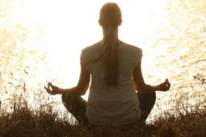 A lady meditating on a cliff