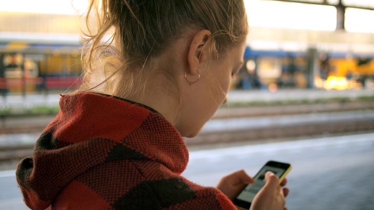 A woman looking at a phone as she contacts drug and alcohol rehab in Bedfordshire