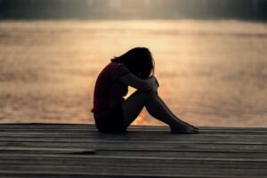 A woman sitting on a decking crying in Maidstone