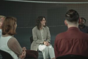 A woman smiling in a group therapy session about addiction at a rehab in Bournemouth