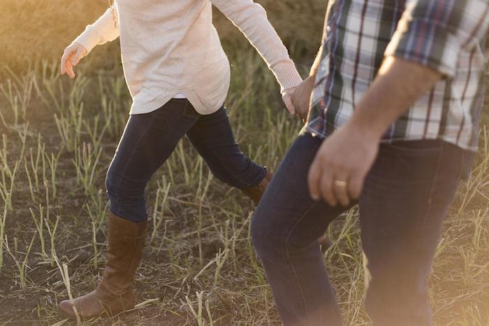 Couple walking through a field during an outdoor therapy session at a drug and alcohol rehab centre in Hampshire