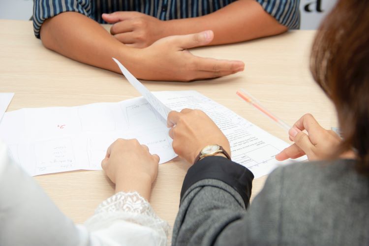 Three people at a table looking through documents