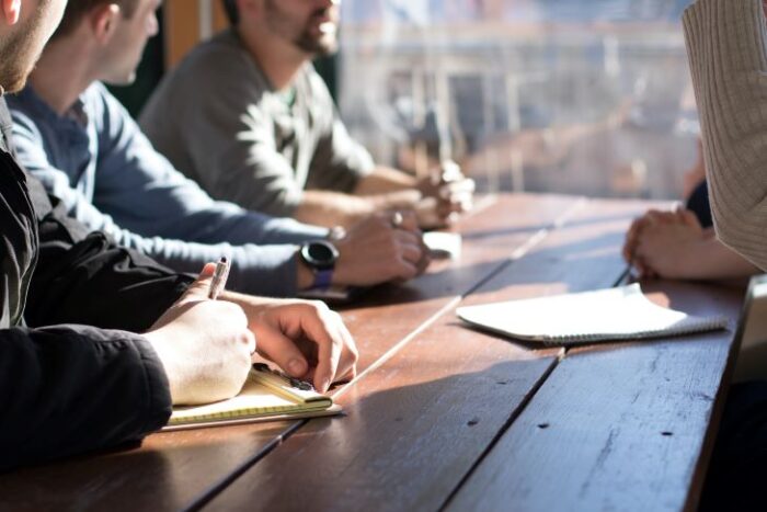 A group of people at a table with notebooks