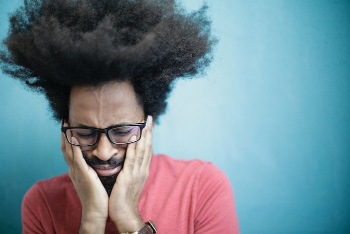 Man holding his face and crying