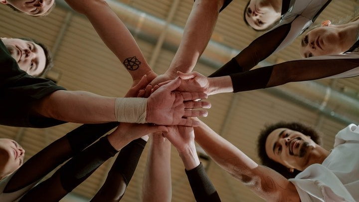 Mutual support group holding hands at a drug and alcohol rehab centre in Gloucestershire