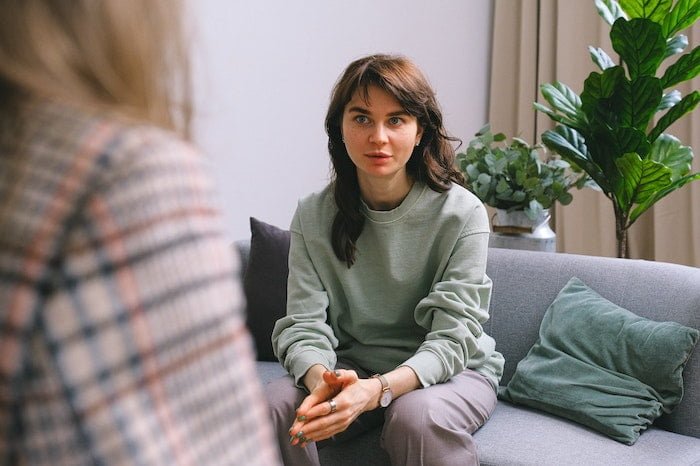 Patient leaning forwards and talking at a drug and alcohol rehab centre in Devon