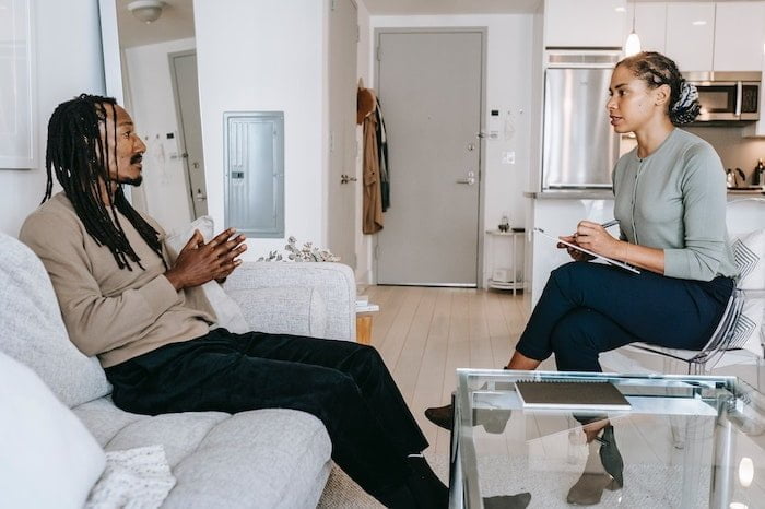 Patient speaking with a therapist in a living room at a drug and alcohol rehab centre in Gloucester