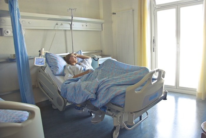 Person lying in a hospital bed at a drug and alcohol rehab in Gloucester