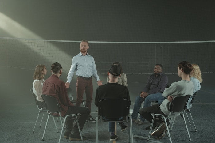 Support group sat in a circle at a drug and alcohol rehab centre in Hertfordshire