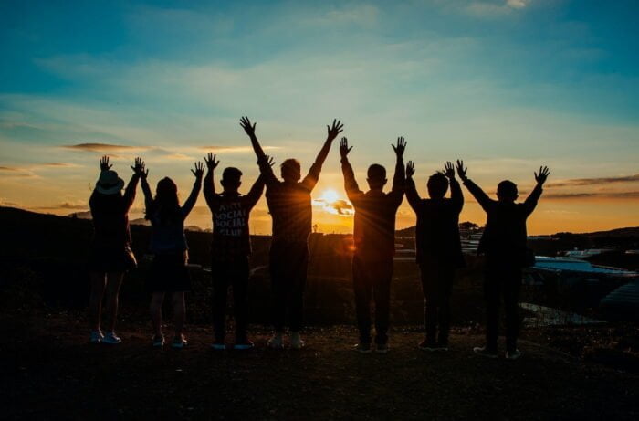 Support group standing together at sunset outside of a drug and alcohol rehab centre in Hereford
