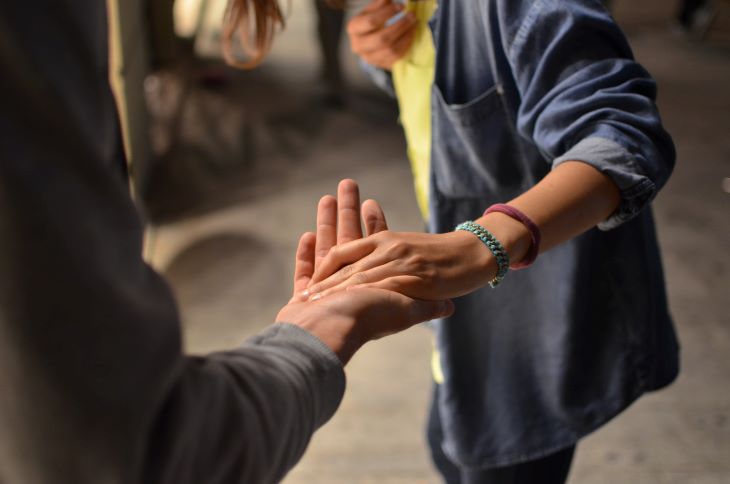 One person holding another person's hand