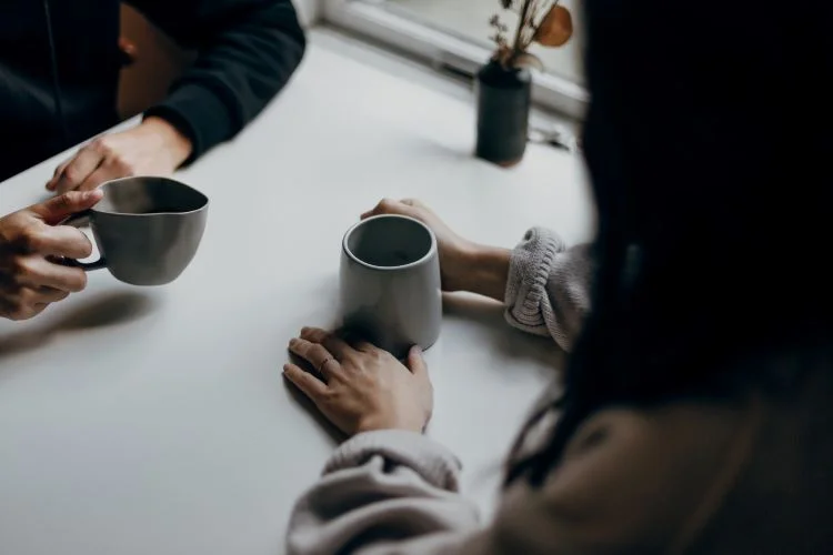 Two people talking over coffee