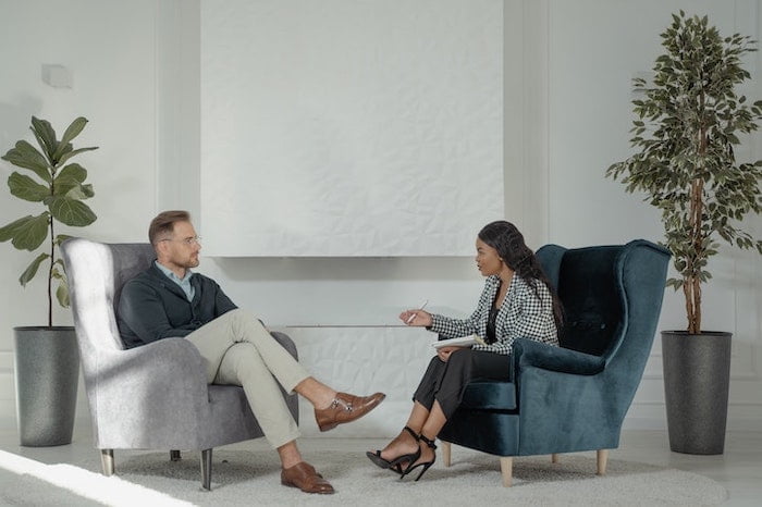 Therapist and patient sat in chairs talking together at a drug and alcohol rehab clinic in Gloucester