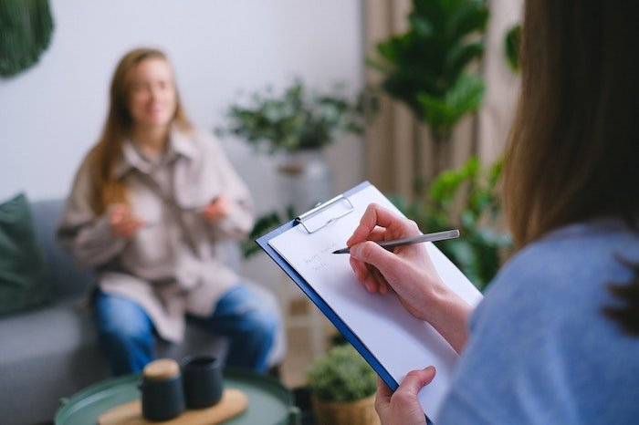 Therapist sat with a patient and taking notes at a drug and alcohol rehab in East Sussex