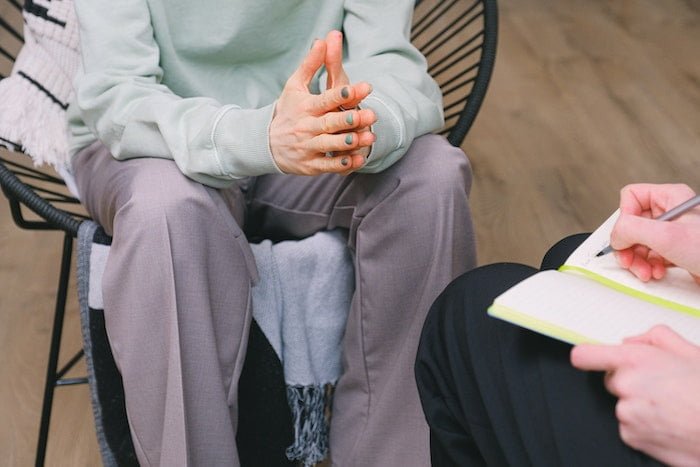 Therapist taking notes whilst sat with a patient at a drug and alcohol rehab in Dorset