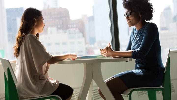 Two people talking at a table at a drug and alcohol rehab in Gloucestershire