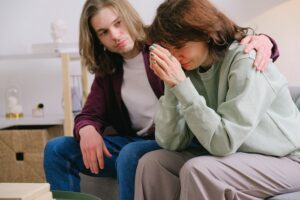 Woman crying and a man comforting her at a rehab in Bristol