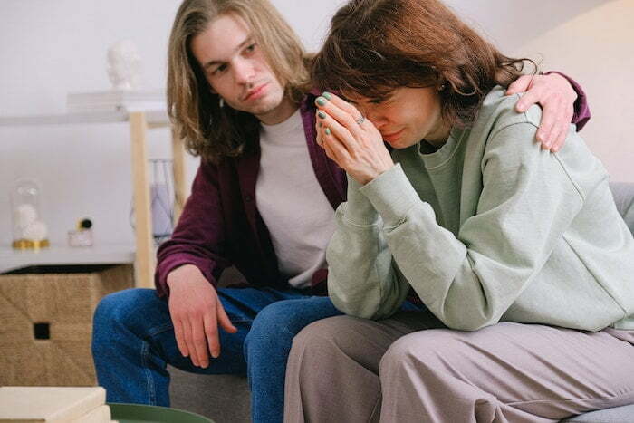 Woman crying and a man comforting her in therapy for drug and alcohol addiction in Buckinghamshire