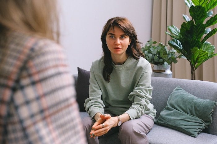 a woman in a Barnsley therapy session at drug and alcohol rehab, sitting on a sofa