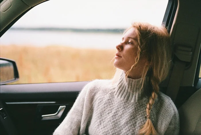 woman looking out a car window