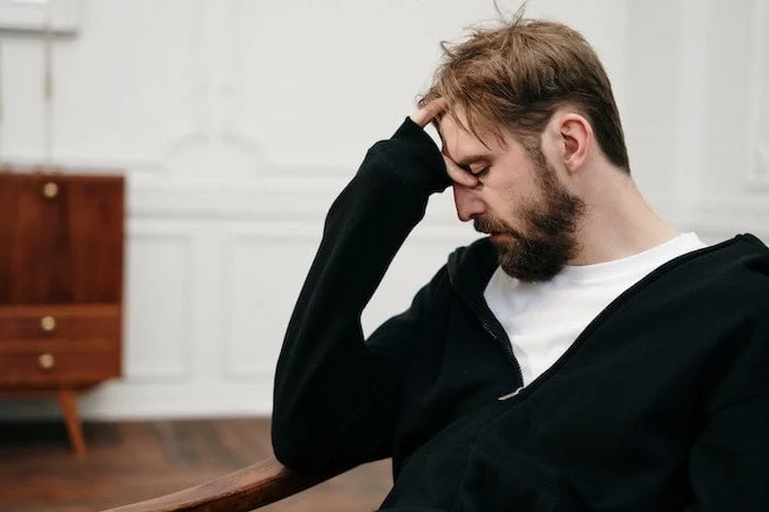 Man holding his head at a drug and alcohol rehab centre in Ipswich