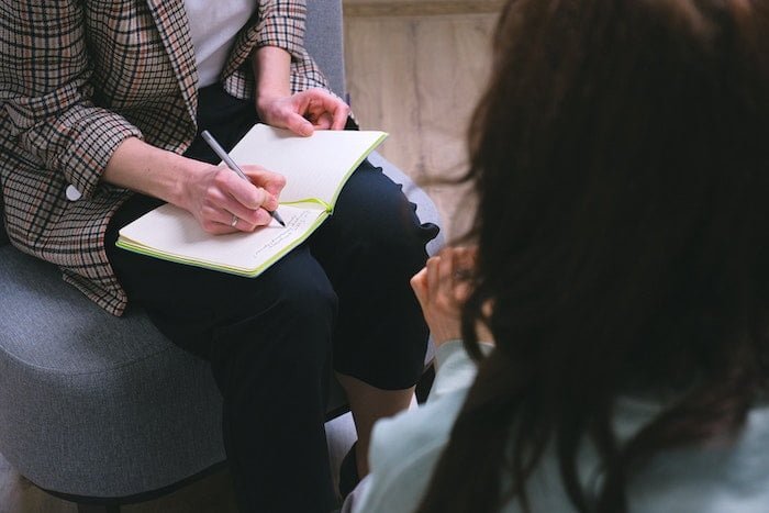 Therapist taking notes with a patient at a drug and alcohol rehab clinic in Ipswich