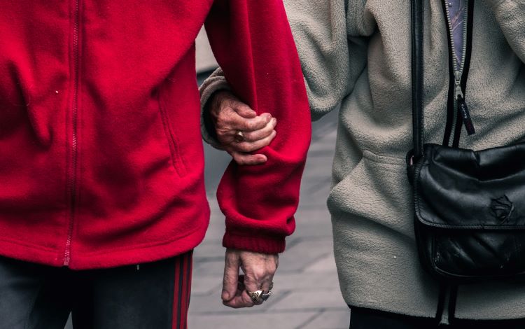 An elderly couple linking arms