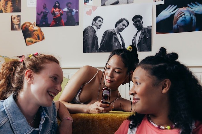 three teenage girls chatting in their bedroom