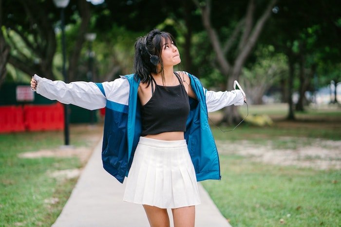 young woman dancing to her music outside