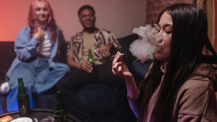 A woman blowing smoke from a cigarette