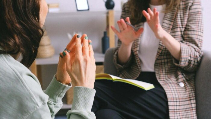 A woman in therapy, her hands clasped