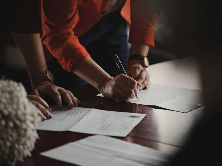 People signing paperwork