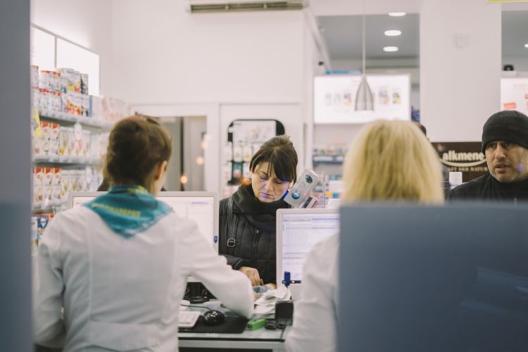 Staff and customers at a pharmacy counter