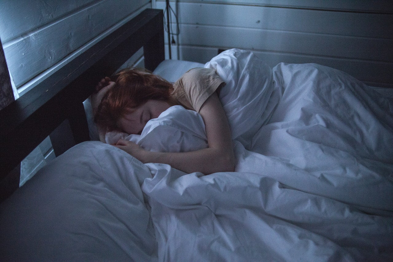 A woman sleeping in a dimly lit room