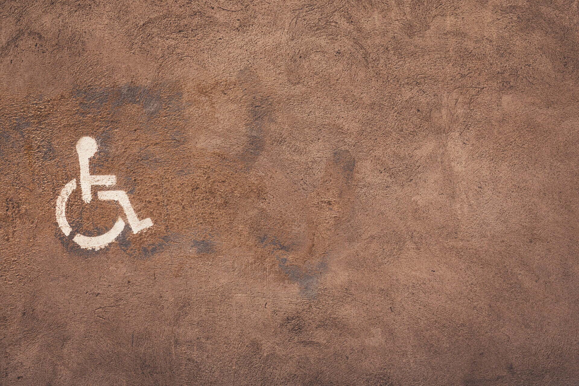 A painted wheelchair symbol on brown background 