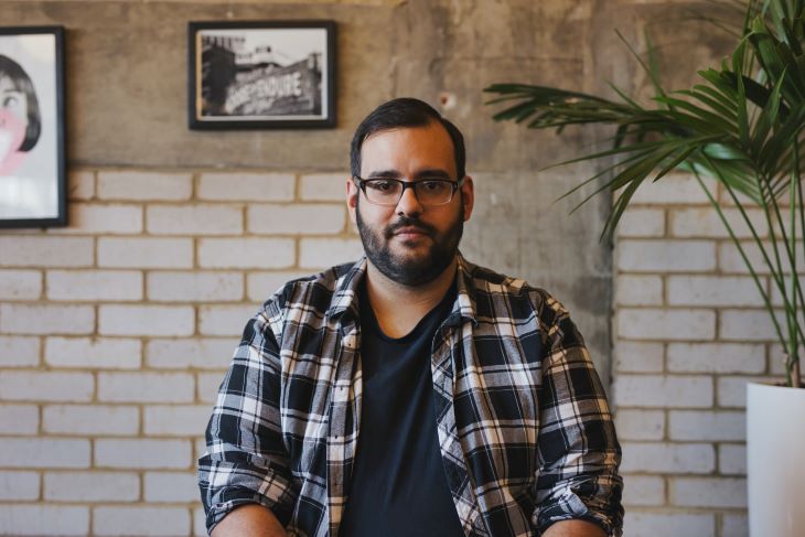 A man looking into the camera with a neutral expression