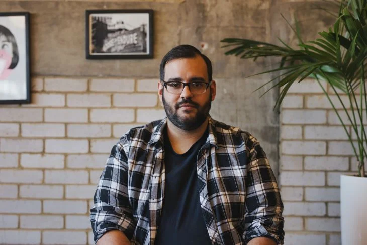 A man looking into the camera with a neutral expression