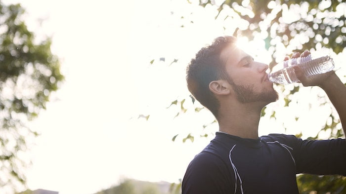 man drinking water outside