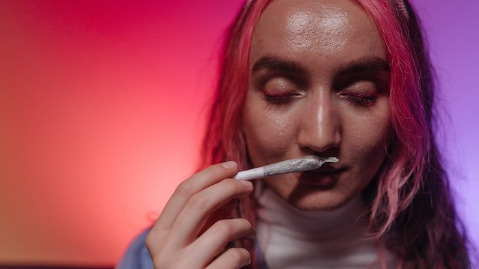 woman holding spliff to her nose