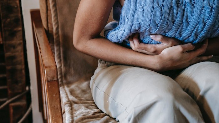 woman holding stomach in pain