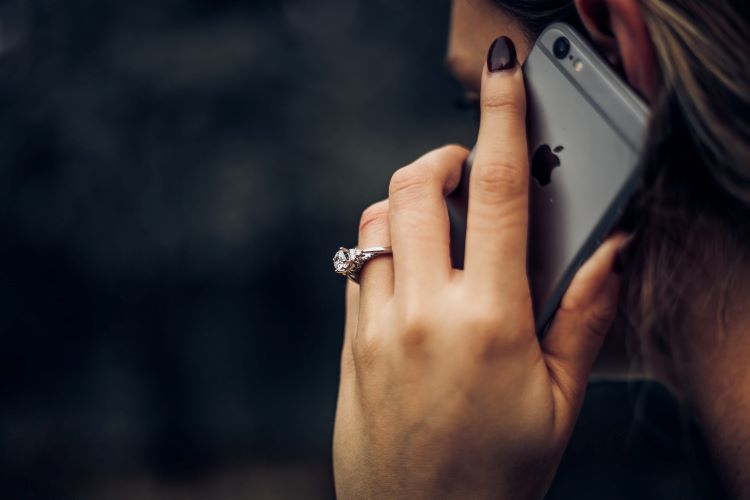 A woman talking on the phone with a ring on her hand