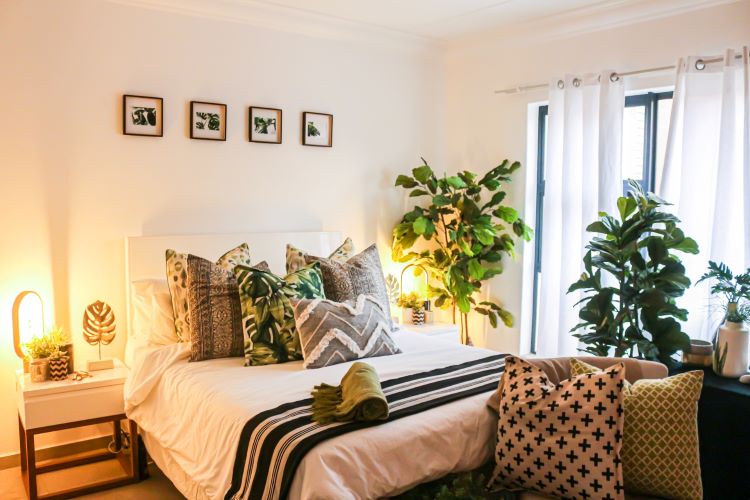 A bedroom with neutral scatter cushions