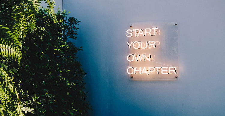 A neon light that says 'start your own chapter'