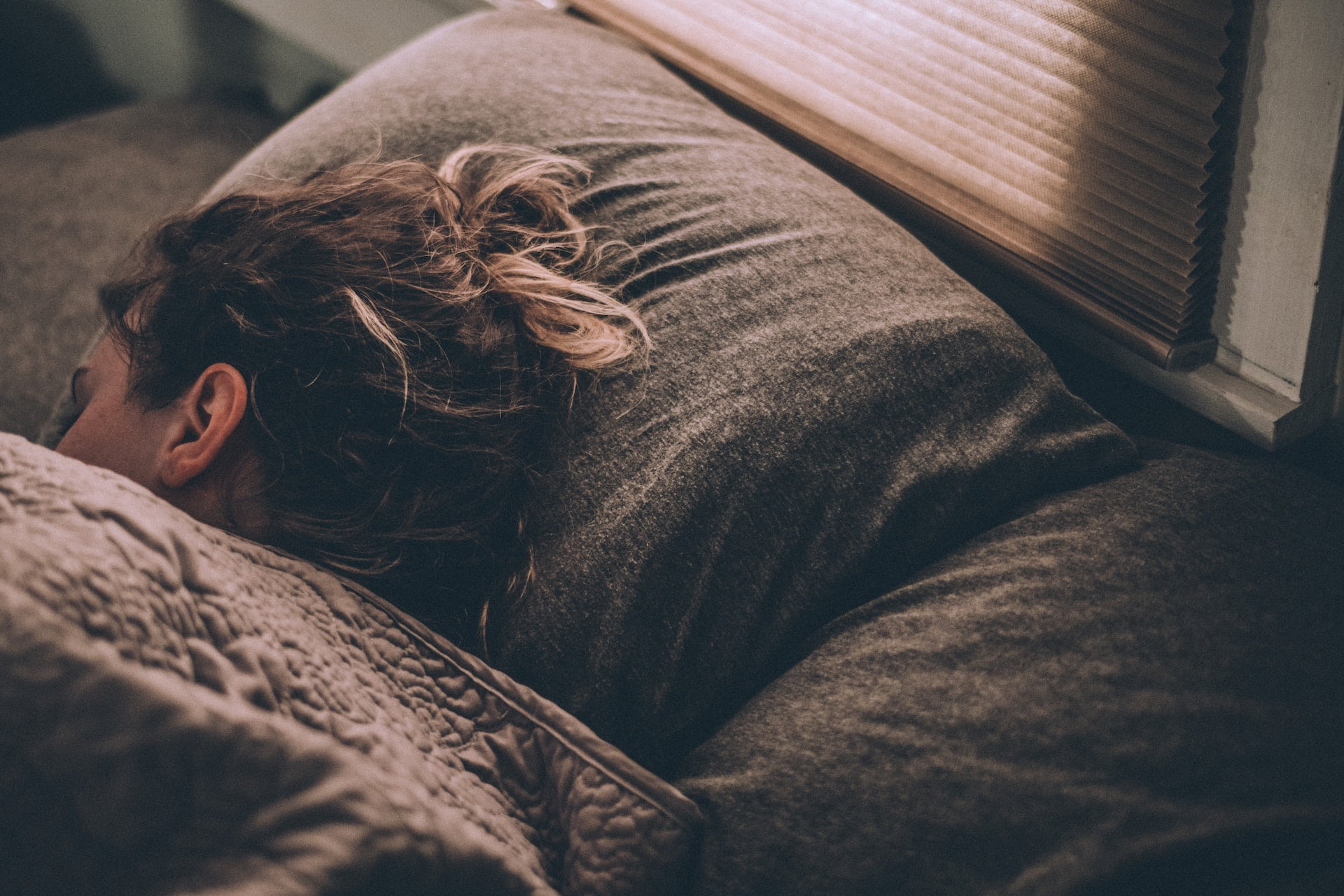 A woman sleeping in bed at an outpatient rehab for addiction