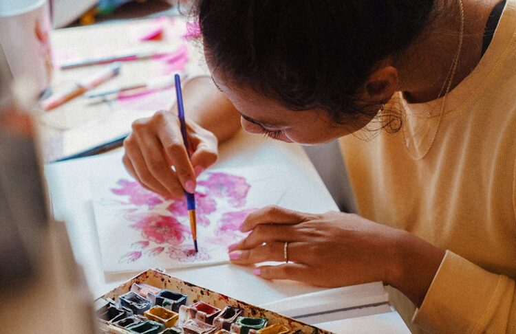 A woman painting in art therapy for addiction