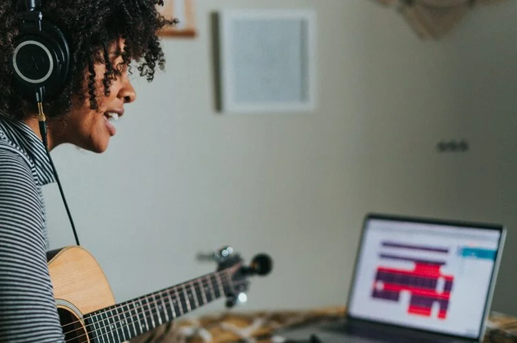 A woman playing guitar and singing during a music therapy session for addiction recovery