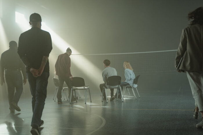 Narcotics Anonymous support group assembling in a sports hall